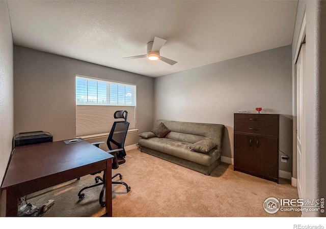 carpeted office with ceiling fan and baseboards