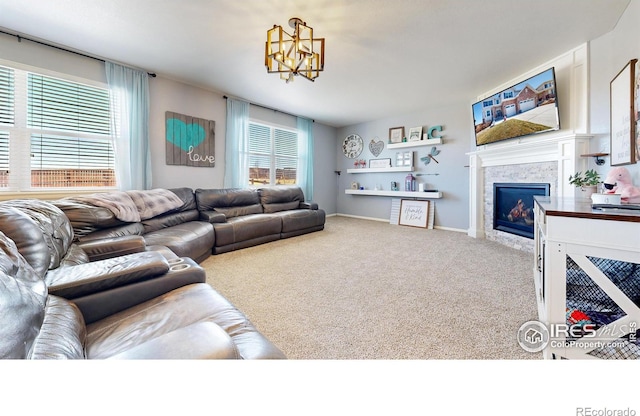 living room featuring a warm lit fireplace, carpet, and a chandelier