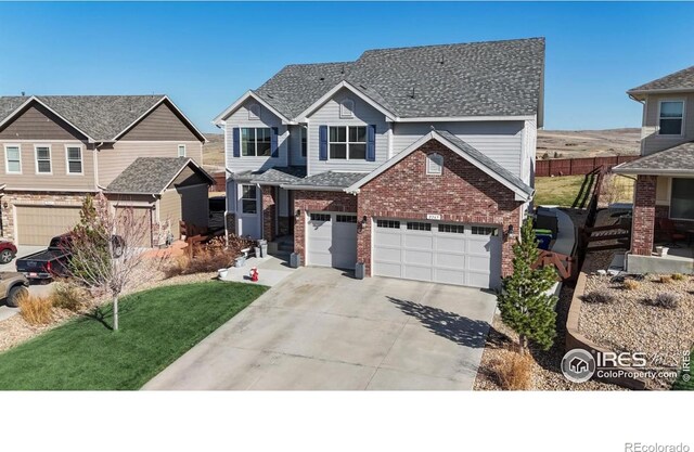 view of front of house featuring a garage, concrete driveway, brick siding, a front lawn, and roof with shingles