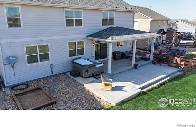 back of property with roof with shingles, a patio, and a residential view