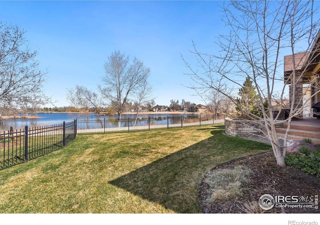 view of yard featuring a water view and fence