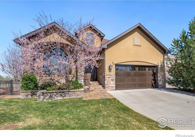 view of front of property with stucco siding, driveway, stone siding, a front yard, and fence