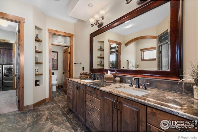 full bath featuring toilet, built in features, double vanity, and a sink