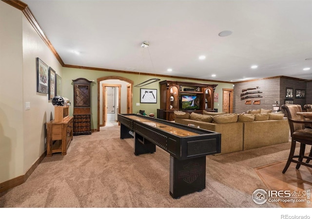 rec room featuring baseboards, arched walkways, crown molding, recessed lighting, and light colored carpet