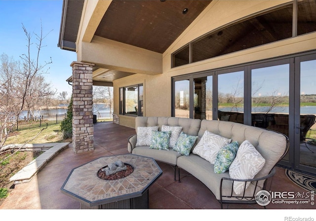 view of patio featuring a water view, outdoor lounge area, and fence