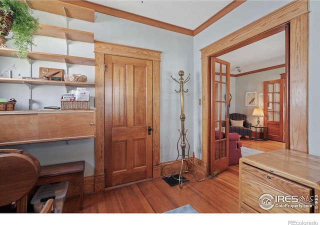 foyer with french doors, ornamental molding, light wood-style flooring, and baseboards
