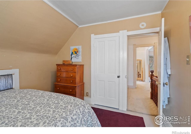 bedroom with vaulted ceiling, crown molding, and carpet floors