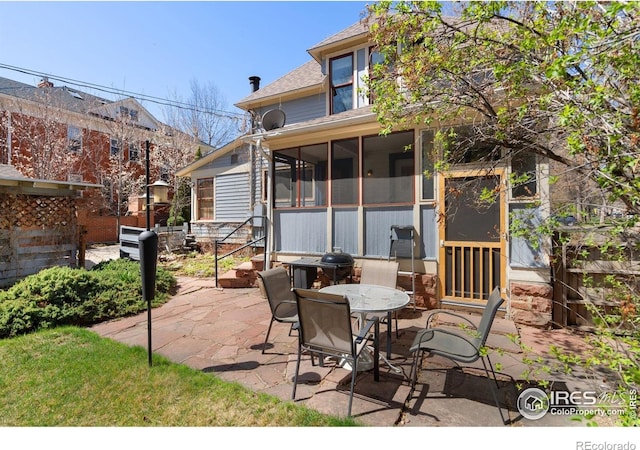 view of patio featuring outdoor dining space and a sunroom