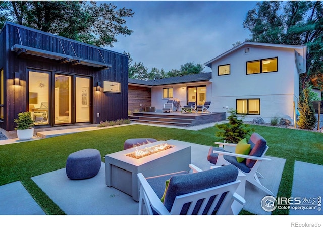 back of house with a patio, a fire pit, and a lawn
