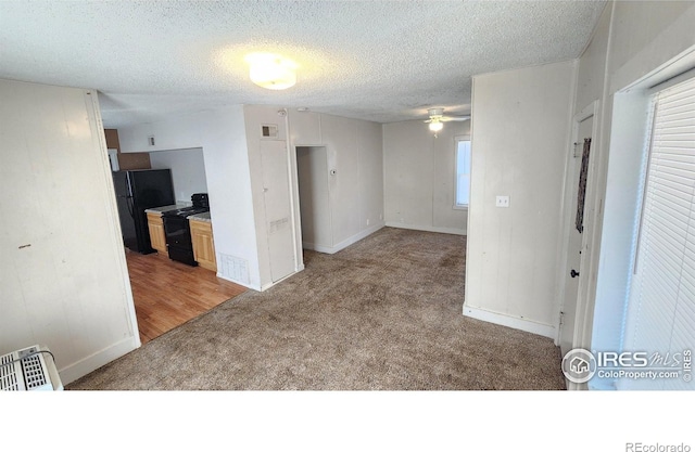 111 N 8th Ave, Sterling, CO 80751 - empty room featuring a textured ceiling, a ceiling fan, visible vents, light carpet, and baseboards