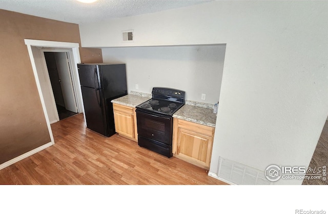 111 N 8th Ave, Sterling, CO 80751 - kitchen featuring visible vents, baseboards, light countertops, light wood-style floors, and black appliances
