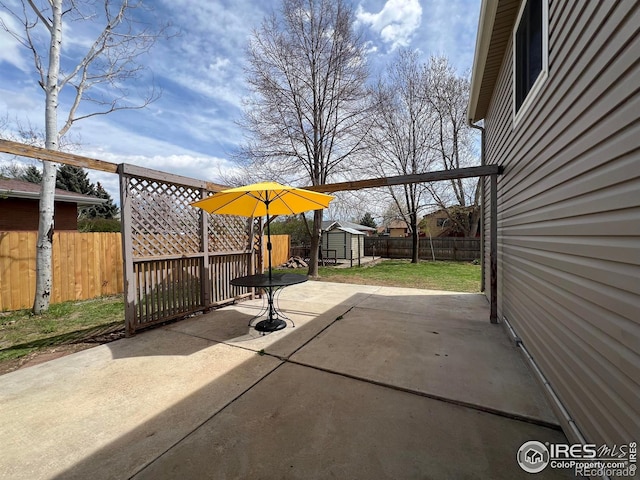 1406 Oak Dr, Berthoud, CO 80513 - view of patio featuring a storage shed, a fenced backyard, and an outbuilding