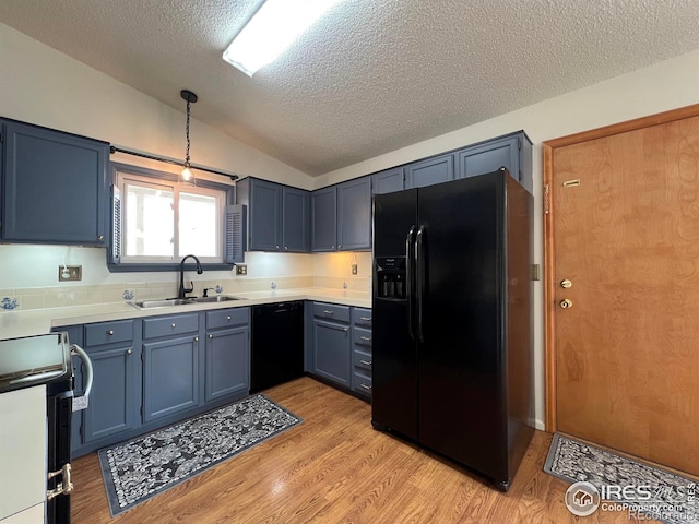 1406 Oak Dr, Berthoud, CO 80513 - kitchen featuring vaulted ceiling, light countertops, a textured ceiling, black appliances, and a sink