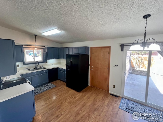 1406 Oak Dr, Berthoud, CO 80513 - kitchen featuring a chandelier, a sink, black fridge, and a textured ceiling