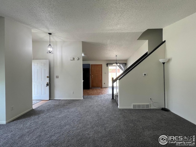 1406 Oak Dr, Berthoud, CO 80513 - unfurnished living room featuring a textured ceiling, an inviting chandelier, carpet, and visible vents