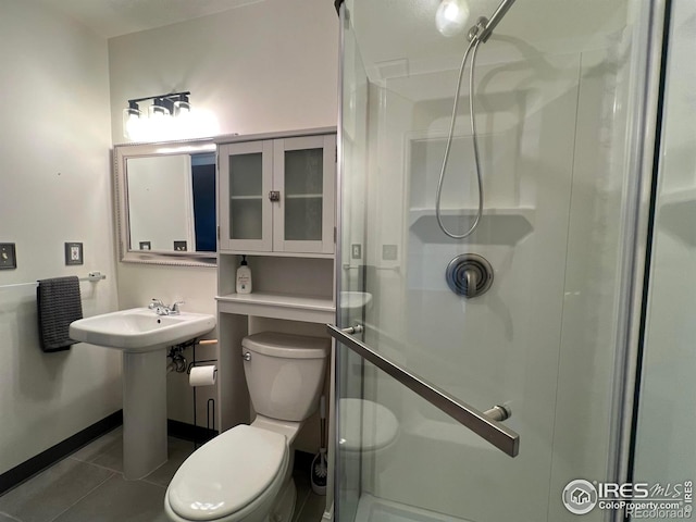 1406 Oak Dr, Berthoud, CO 80513 - bathroom with tile patterned flooring, toilet, a sink, a stall shower, and baseboards