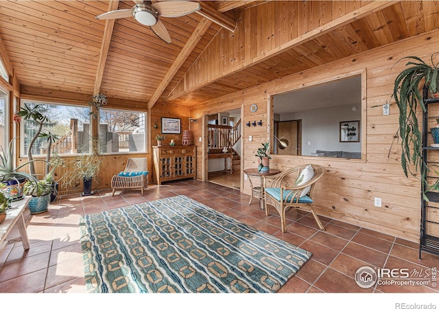interior space featuring tile patterned flooring, wooden walls, wooden ceiling, and a ceiling fan