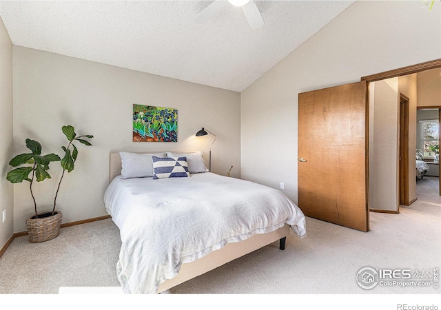 carpeted bedroom with baseboards, a ceiling fan, and vaulted ceiling