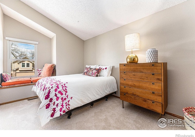 carpeted bedroom featuring visible vents, baseboards, vaulted ceiling, and a textured ceiling