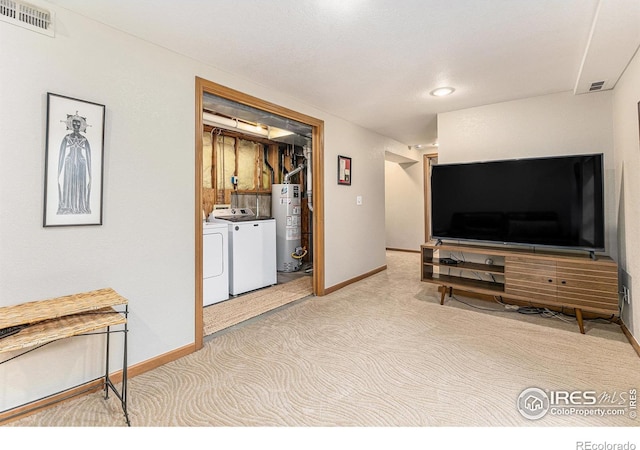living area with baseboards, gas water heater, carpet floors, visible vents, and washer and dryer