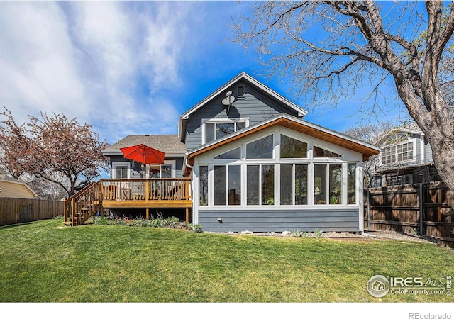 back of property featuring a sunroom, a lawn, fence, stairs, and a deck