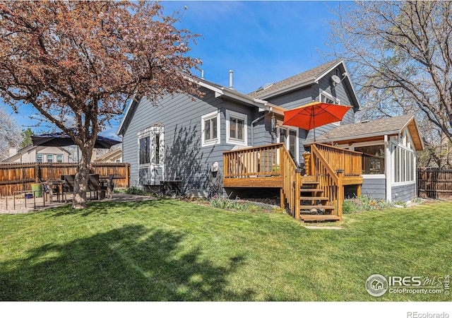 back of property featuring a patio, a fenced backyard, a wooden deck, and a lawn