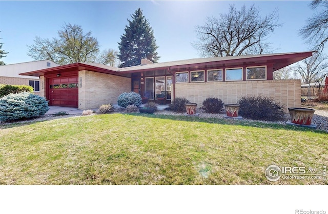 619 Monte Vista Ave, Fort Collins, CO 80521 - view of front of house featuring a garage, a front yard, and brick siding