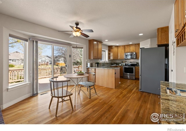 4748 Westbury Dr, Fort Collins, CO 80526 - kitchen featuring stainless steel appliances, light wood-type flooring, a ceiling fan, and open shelves