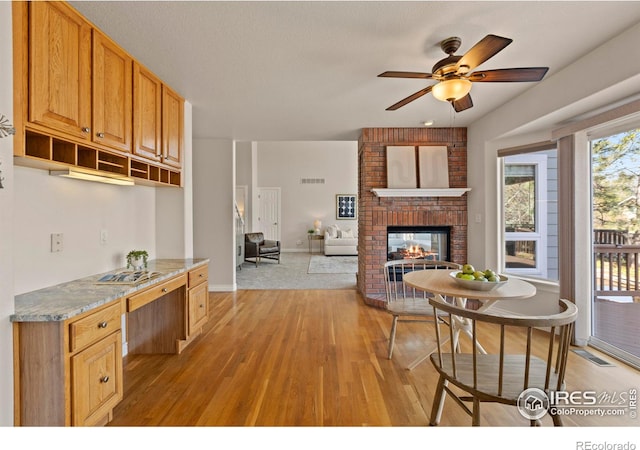4748 Westbury Dr, Fort Collins, CO 80526 - interior space featuring a fireplace, light wood-style floors, visible vents, and a ceiling fan