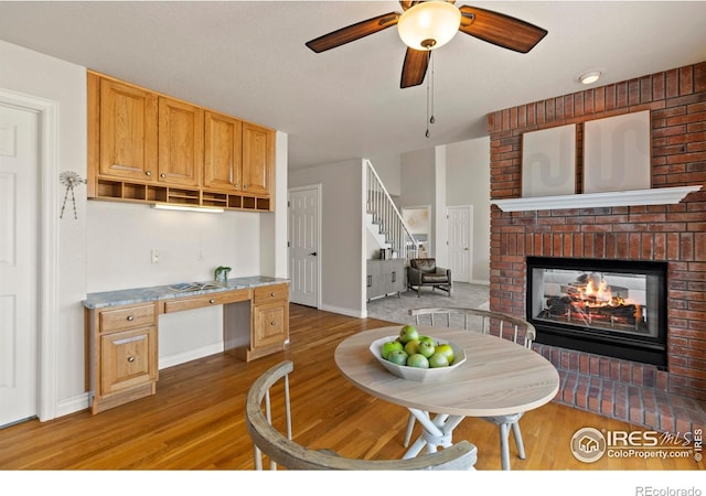 4748 Westbury Dr, Fort Collins, CO 80526 - interior space with light wood finished floors, a brick fireplace, light countertops, and a ceiling fan