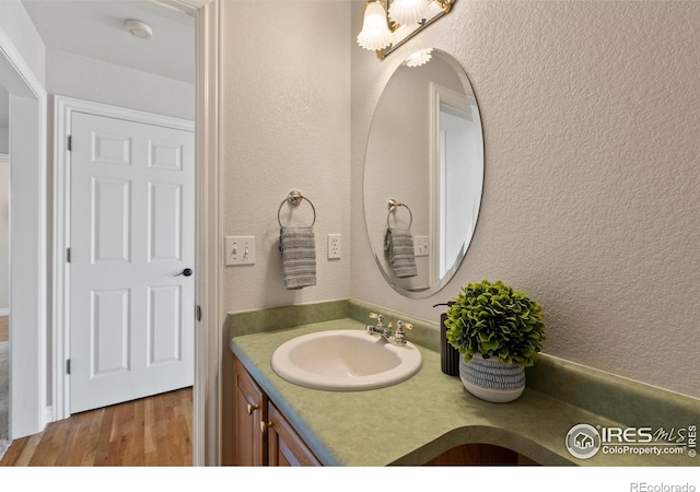 4748 Westbury Dr, Fort Collins, CO 80526 - bathroom with a chandelier, a textured wall, vanity, and wood finished floors