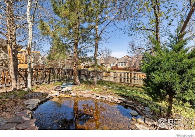 4748 Westbury Dr, Fort Collins, CO 80526 - view of yard featuring a garden pond, a residential view, and fence private yard