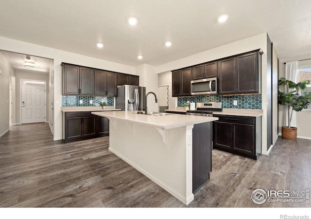 243 Gwyneth Lake Dr, Severance, CO 80550 - kitchen featuring a sink, tasteful backsplash, dark brown cabinetry, light countertops, and appliances with stainless steel finishes