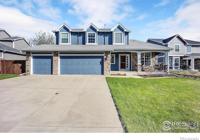 craftsman house with stone siding, covered porch, fence, a front lawn, and driveway