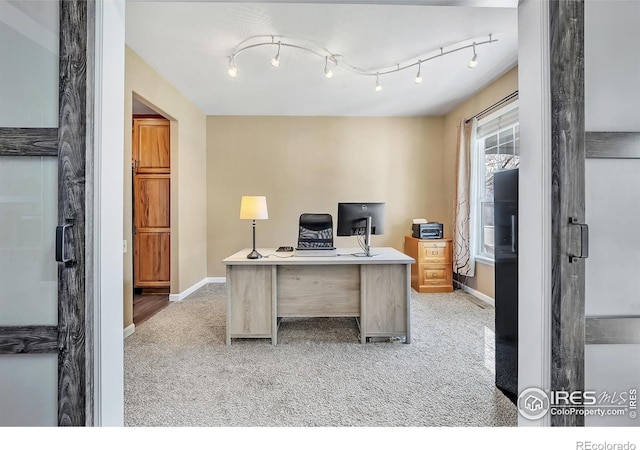 office space featuring light carpet and baseboards