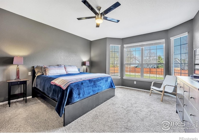 carpeted bedroom with baseboards and a ceiling fan
