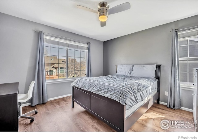 bedroom featuring wood finished floors, baseboards, and a ceiling fan