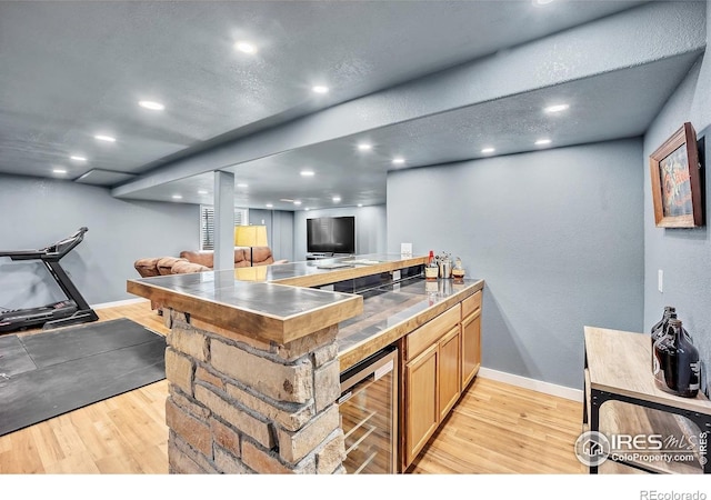 bar with baseboards, a textured wall, recessed lighting, wine cooler, and light wood finished floors