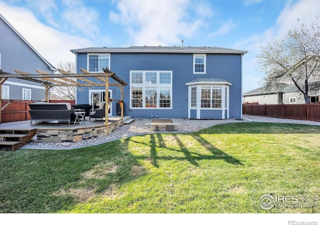 rear view of house with a deck, a pergola, fence private yard, and a lawn