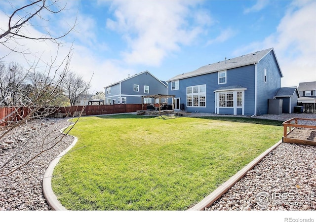 rear view of house with a patio area, a fenced backyard, and a yard