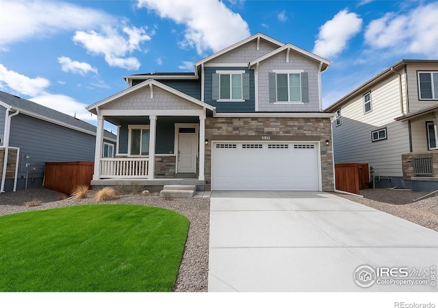 1960 Thundercloud Dr, Windsor, CO 80550 - craftsman-style home featuring covered porch, stone siding, an attached garage, and driveway