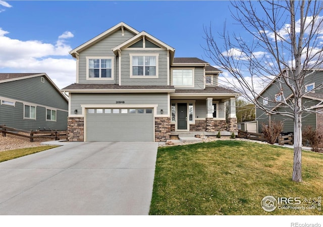 16848 Weber Way, Mead, CO 80542 - craftsman-style home with covered porch, an attached garage, concrete driveway, a front lawn, and stone siding