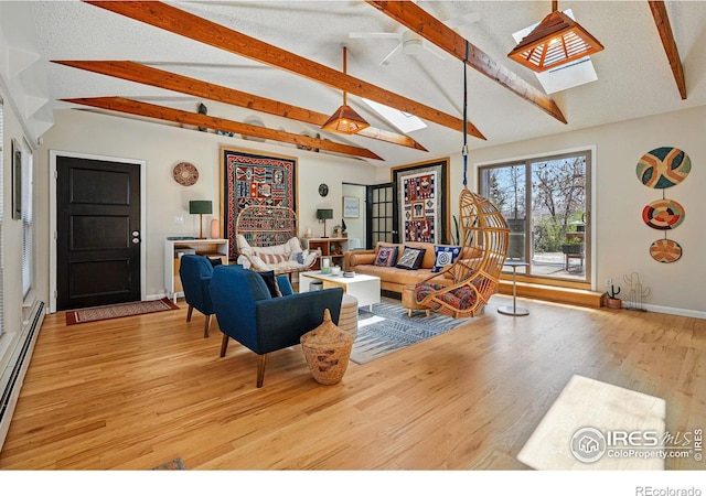 living room with baseboards, a baseboard heating unit, wood finished floors, and lofted ceiling with skylight