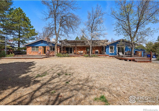 view of front of house featuring brick siding and a wooden deck