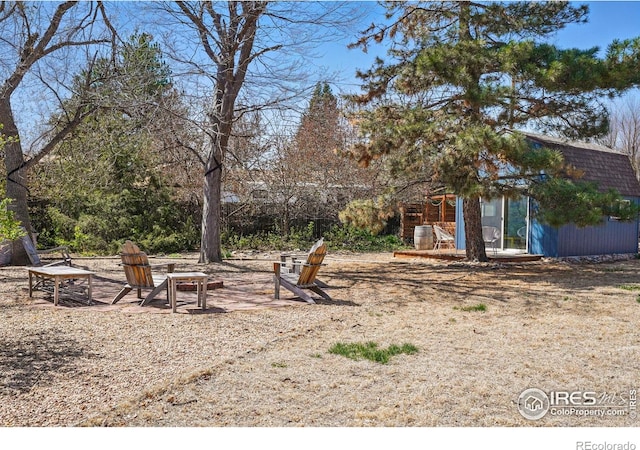 view of yard with an outdoor structure and an outdoor fire pit