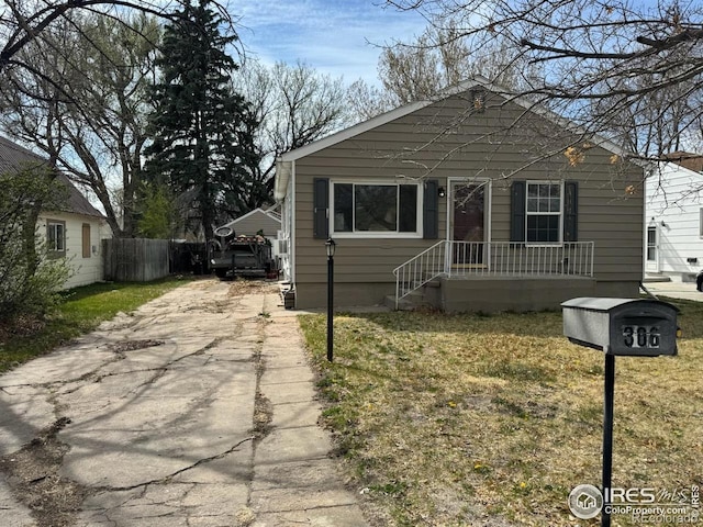 view of front of home featuring concrete driveway and fence