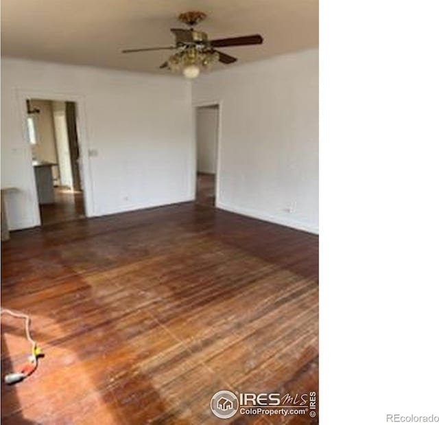 spare room featuring ceiling fan, wood finished floors, and baseboards