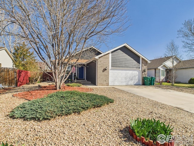 single story home featuring an attached garage, driveway, fence, and brick siding