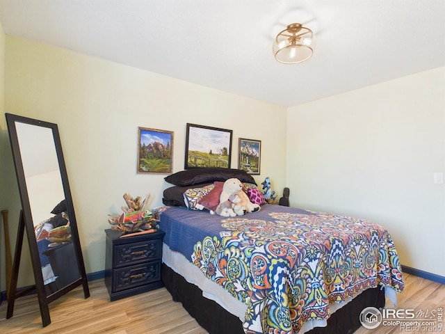bedroom with wood finished floors and baseboards