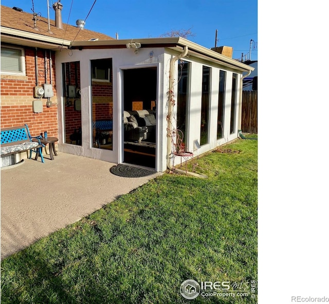 7170 Zuni St, Denver, CO 80221 - back of house with brick siding, fence, a patio, and a lawn